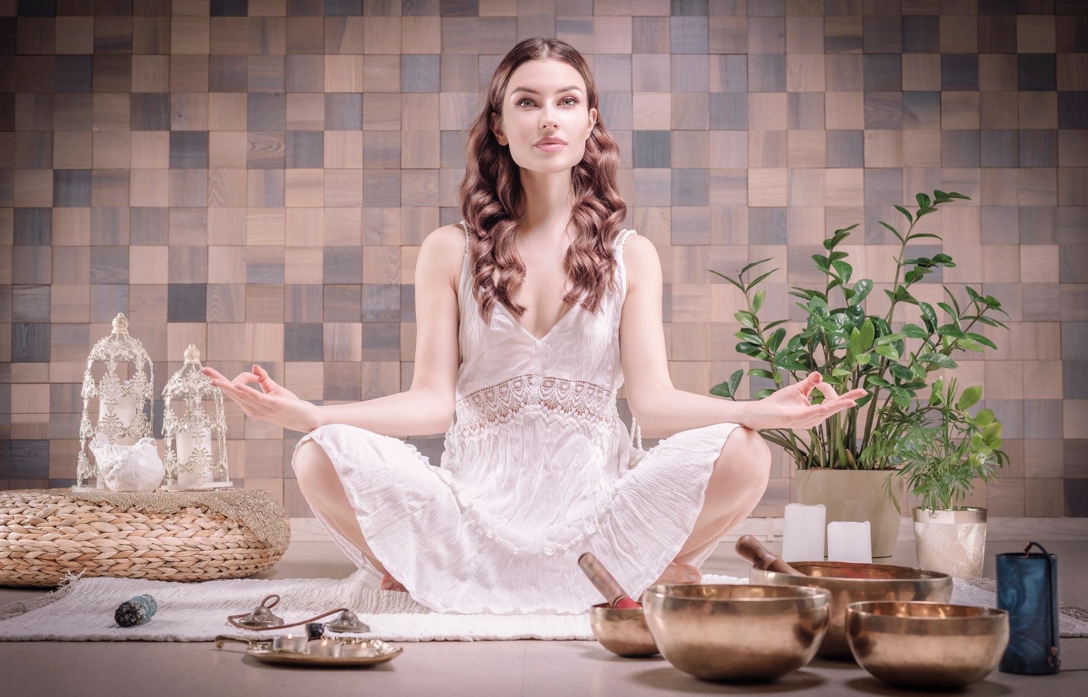 Woman meditating with crystals and singing bowls